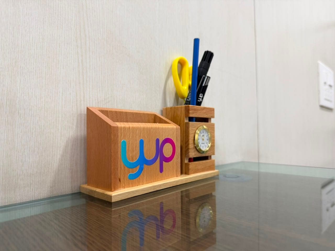A branded desk tidy on the glass-topped desk in a consultation room