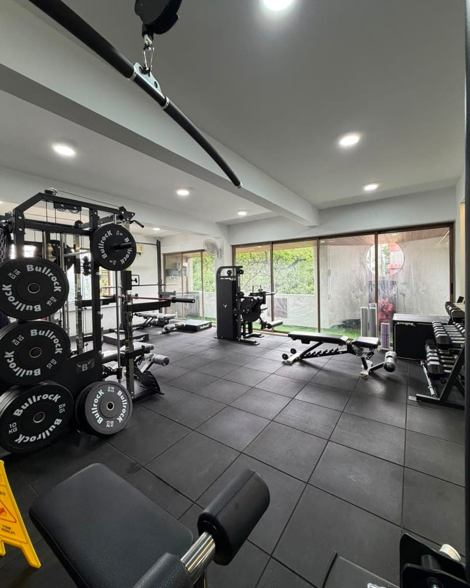 The training studio, with a squat rack, loaded plates and benches